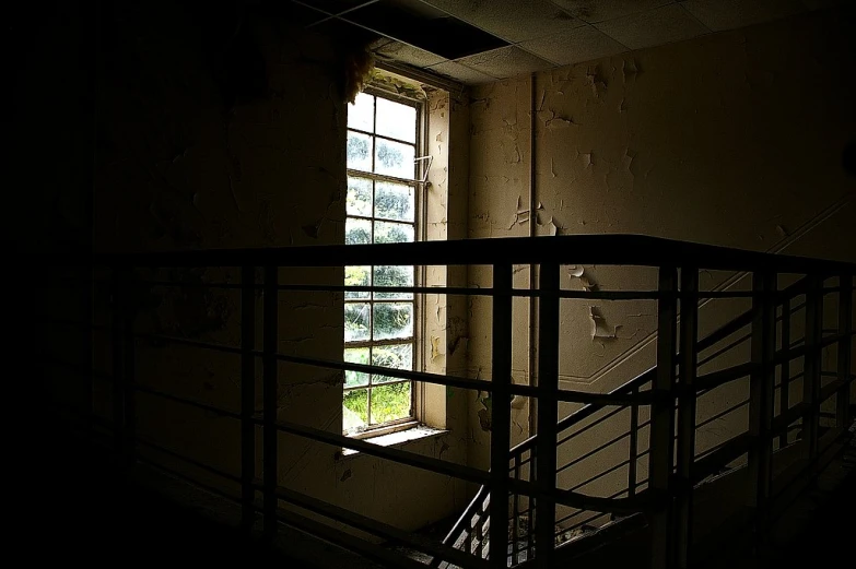 a dark room with a window and stairwell
