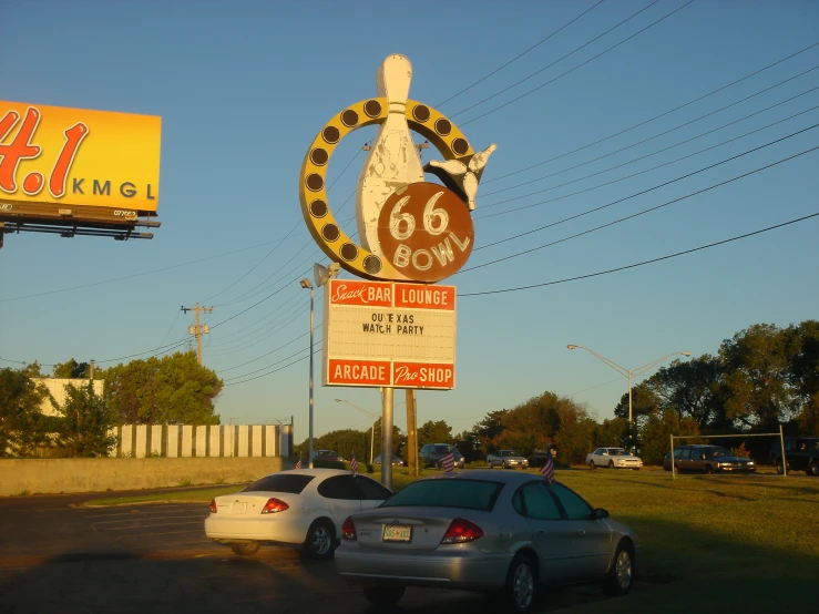 a view of the city sign and cars in front of it