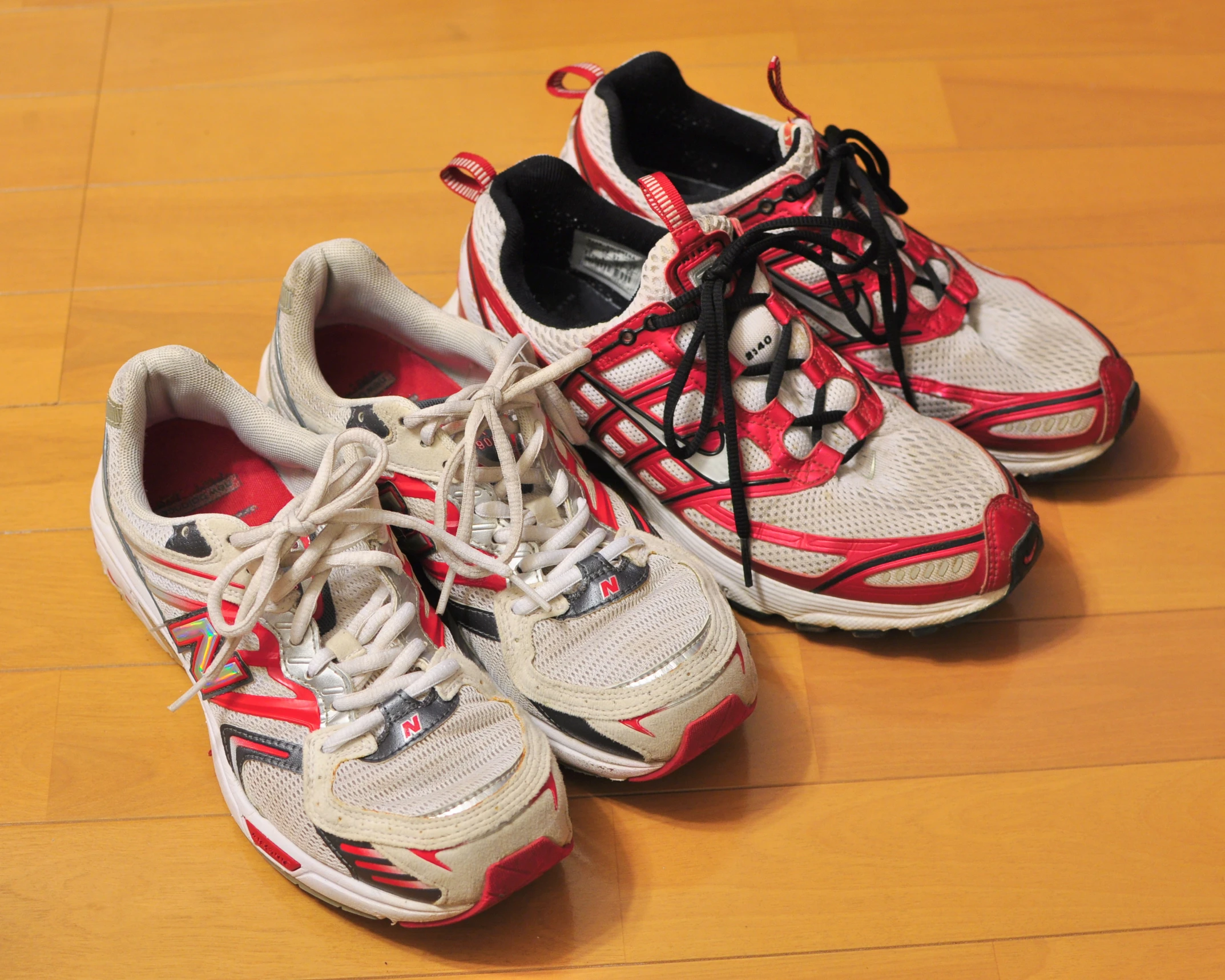 pair of tennis shoes on hardwood flooring looking like they may be worn