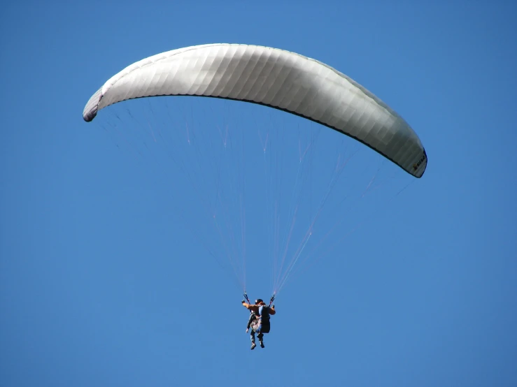 two people are in the air while paragliding