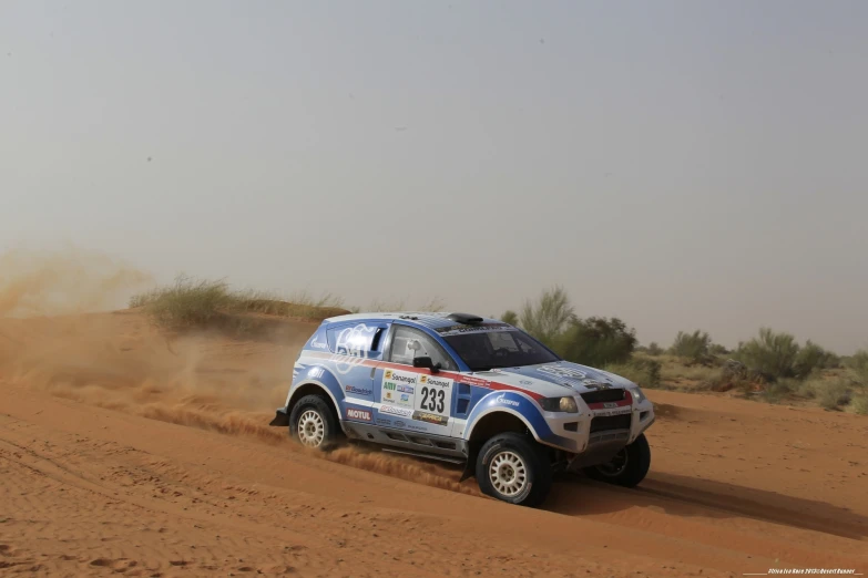 the blue truck is driving through the desert