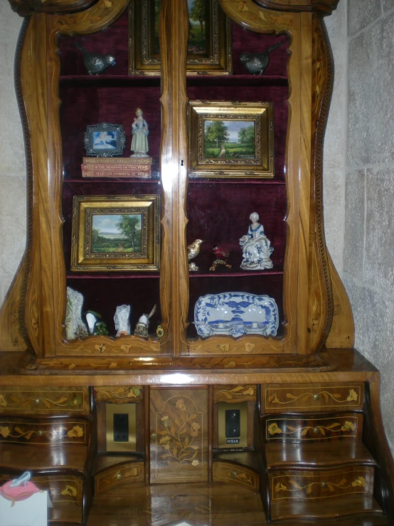 an antique wooden china cabinet with glass front