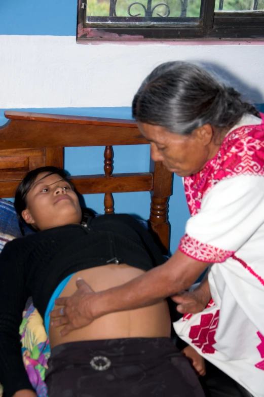 an older woman is lying in a bed next to a boy