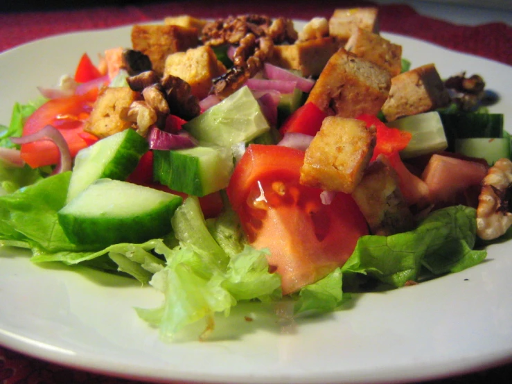 a salad with lettuce, tomato and other food