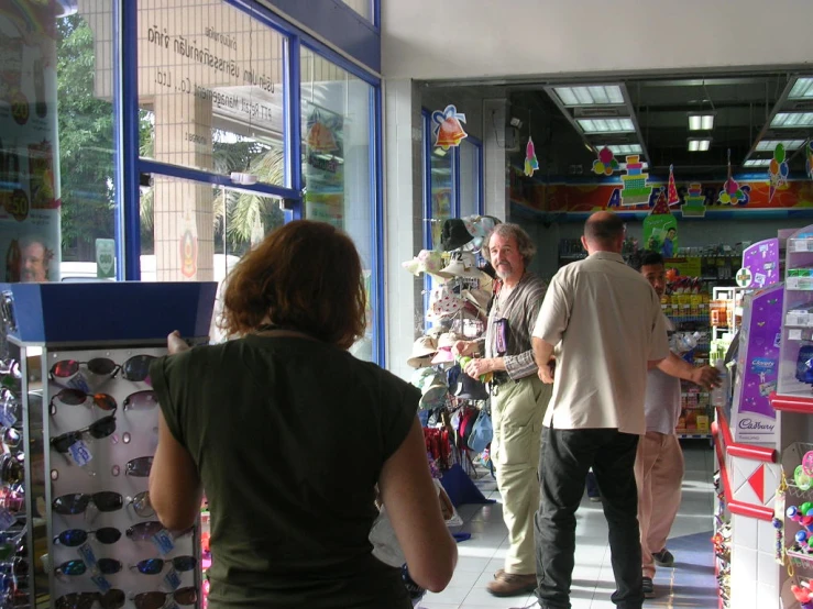 three people standing around and talking inside of a store