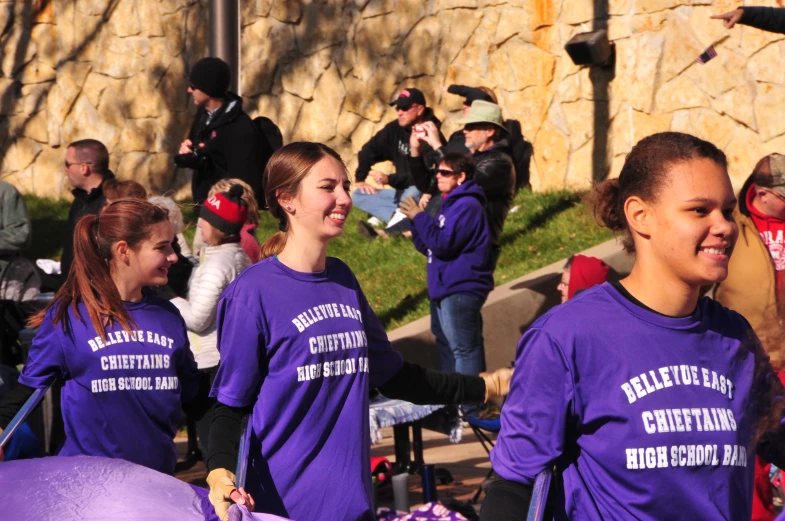 some people walking on a street and some have purple shirts on