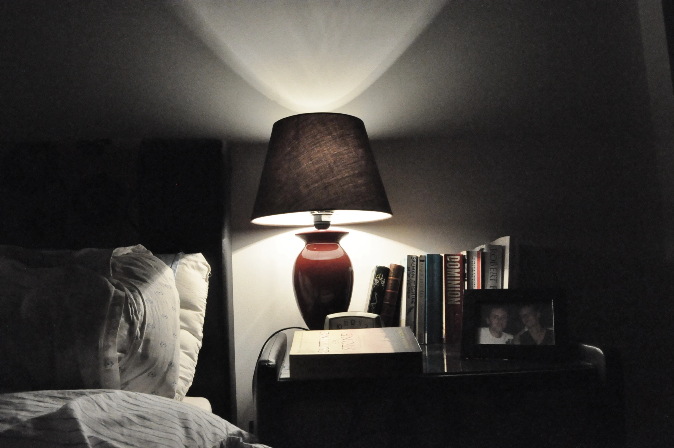 a bedroom with a book and lamp on it