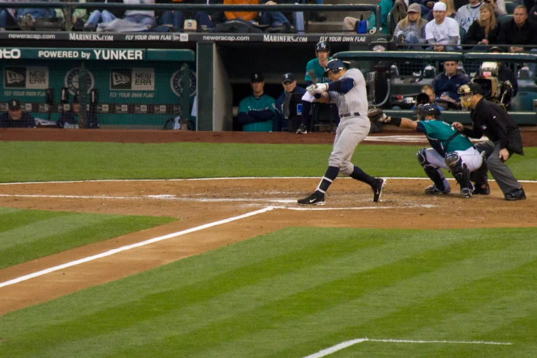 batter at home plate swinging at baseball during game