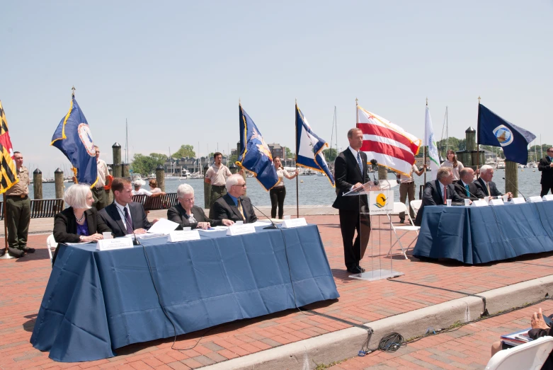 several people sitting at tables with flags around them