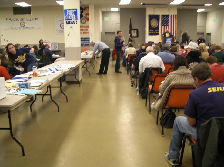 a crowded room filled with tables and people