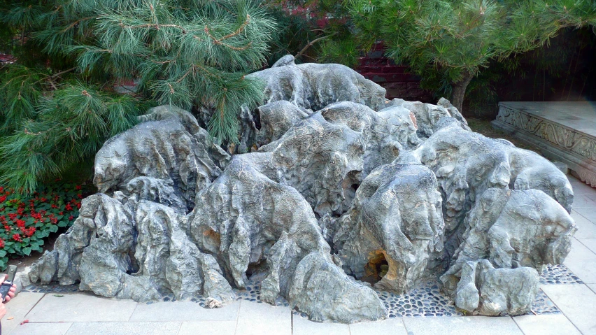 a large pile of rocks sitting next to a bunch of bushes