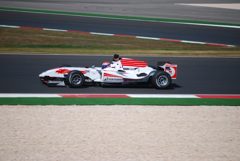 a white race car driving down a street