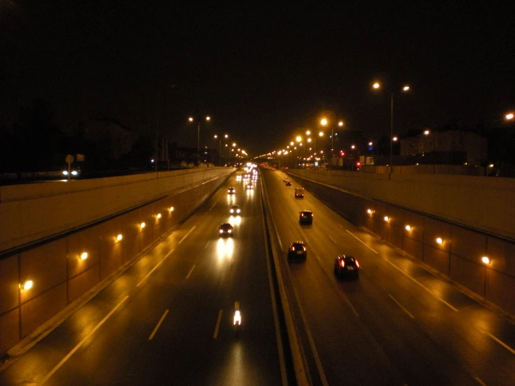 a highway at night with headlights, lights, and vehicles