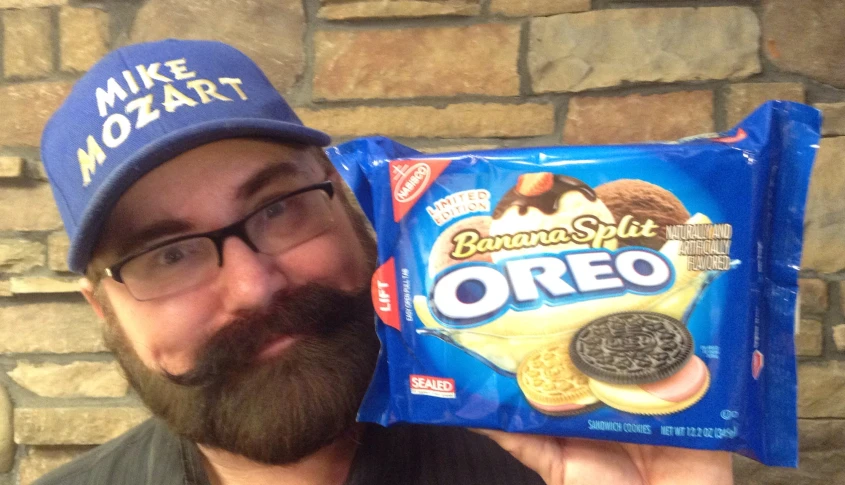 the man is taking a selfie with his bag of oreo cookies