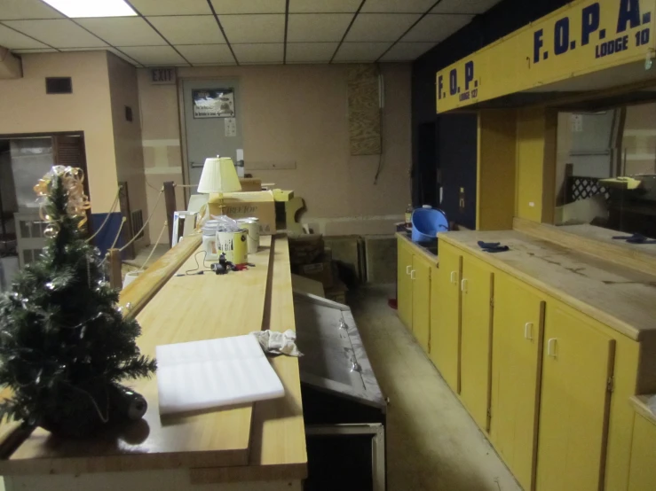 the view of a kitchen with yellow cabinets and tables