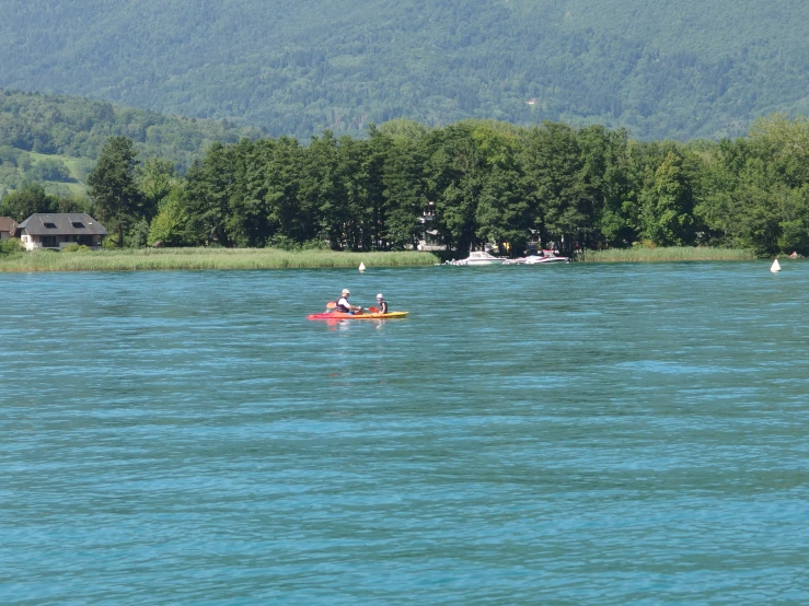 people paddling a small canoe on calm water