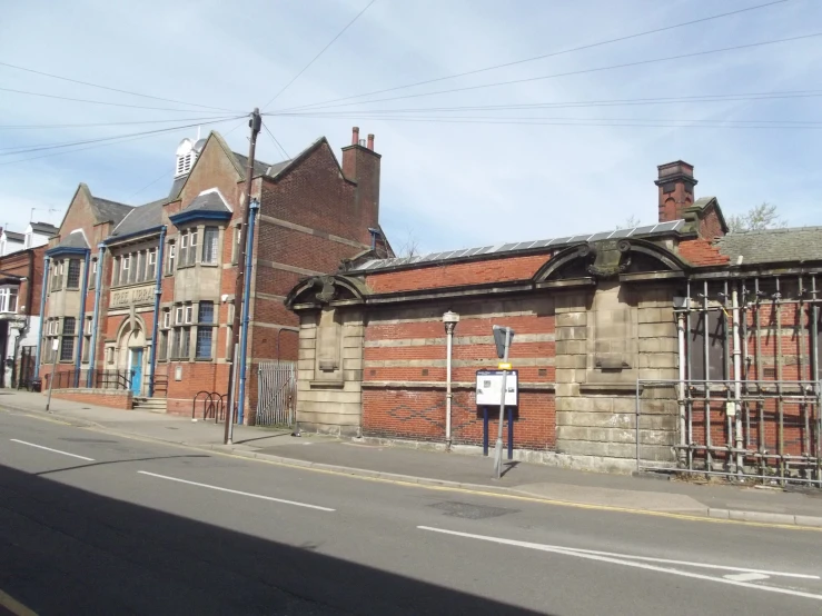 an old brick building is next to the street