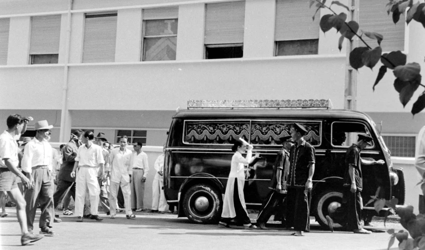 a group of men gathered around an old black van