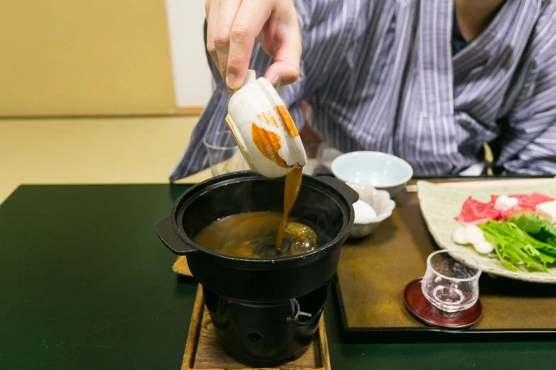 a person cooking in a small pot