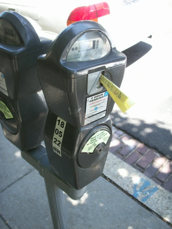 two parking meters with sticky notes stuck on them