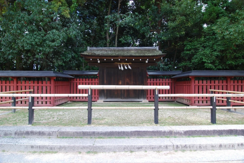 a wooden structure sitting next to a lush green forest