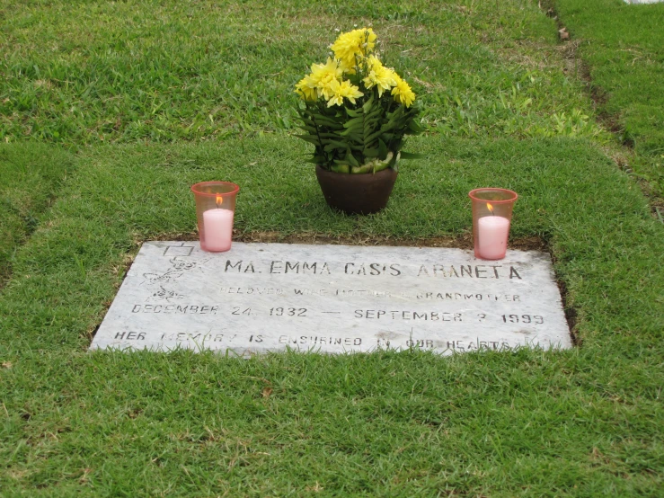 an unlit memorial on the grass is covered in flowers