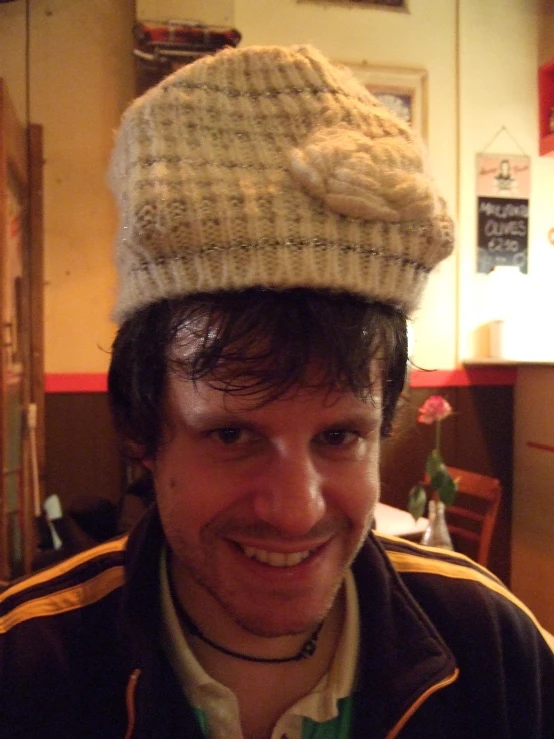 a man smiling wearing a knitted hat and jacket