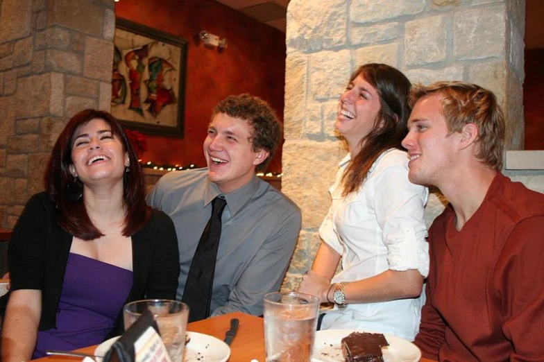a family sitting at a table smiling at the camera
