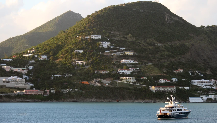 a small boat is docked near a hill