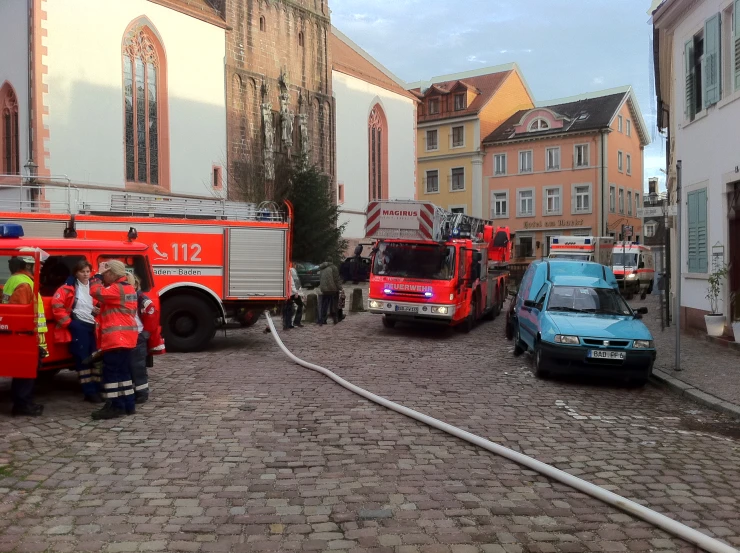 a group of men standing around two fire trucks