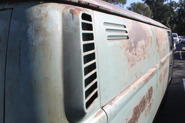 an old van that is rusting off with a few stains