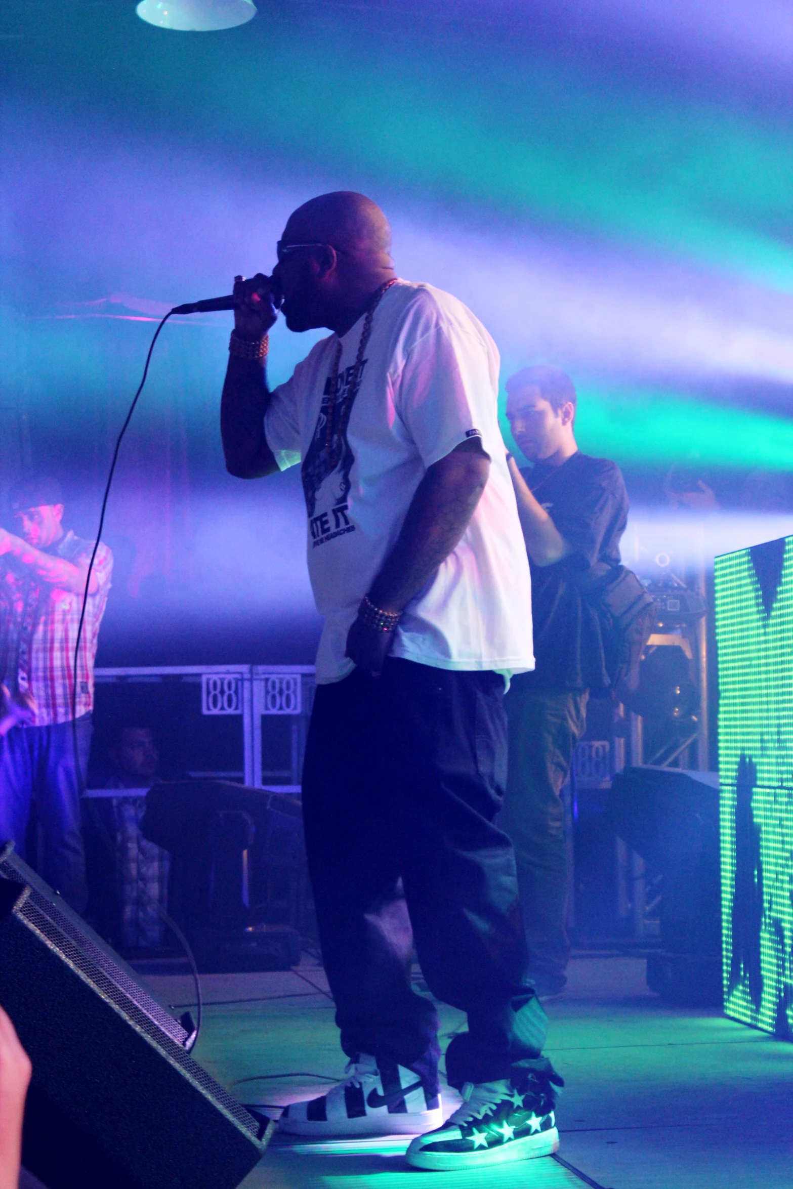 a man standing on a stage while singing into a microphone