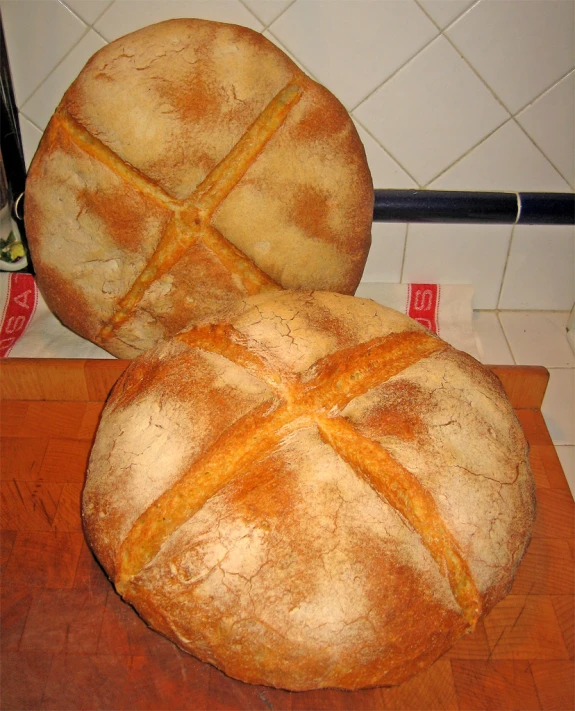 a couple of big round loaves of bread on a counter