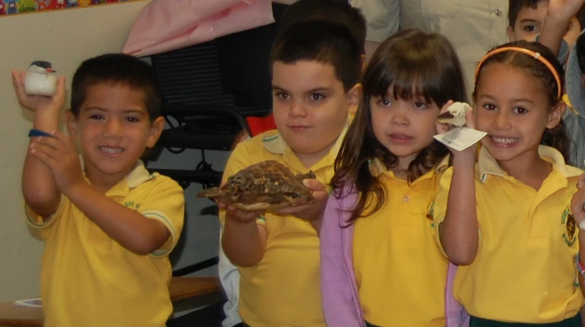 several children holding up pieces of food