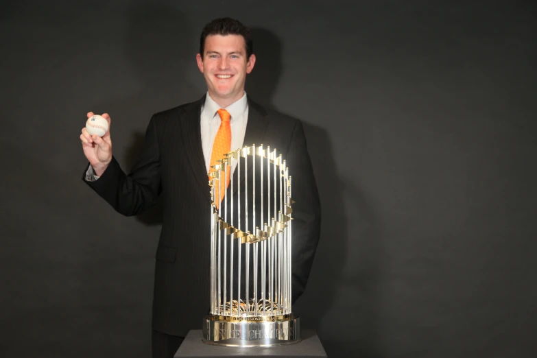 a man in suit and tie holding a trophy