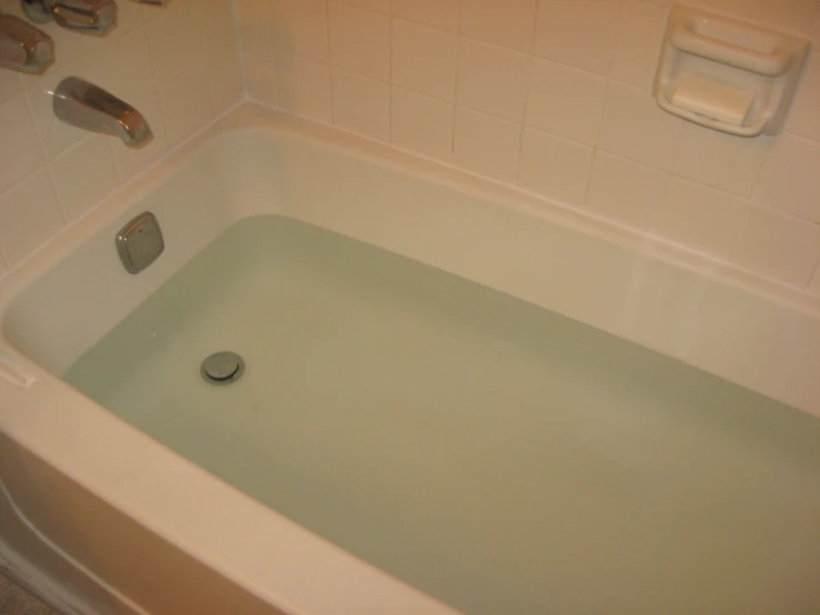 a small white bath tub with green liquid