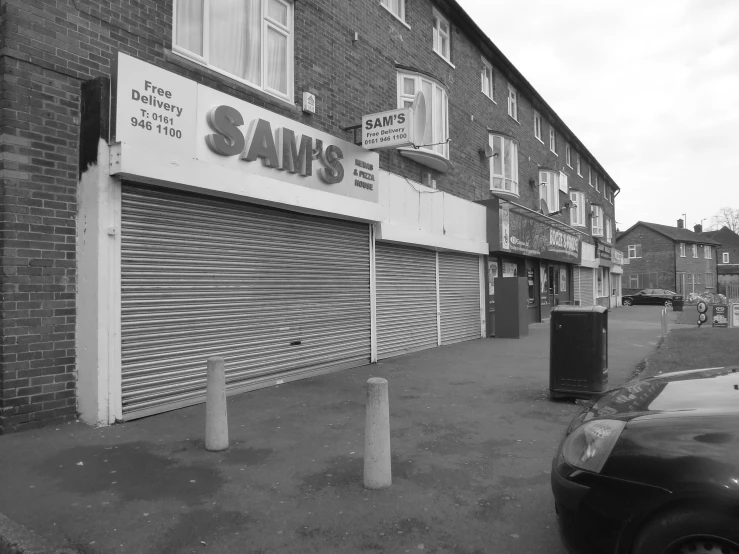 an empty street with a closed door and several tall buildings