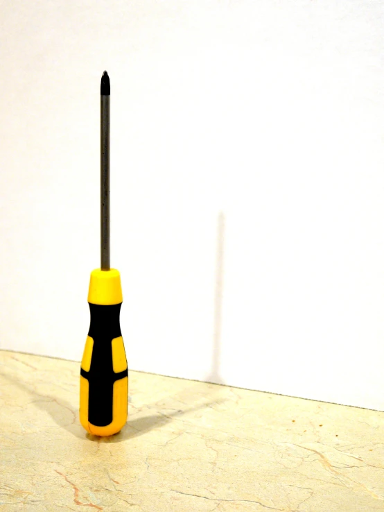 the black and yellow brush is on the white wall