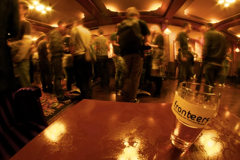 people walking around in a long hallway while drinking beer