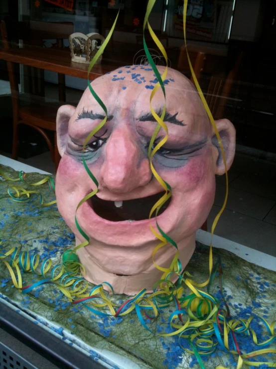 a sculpture is smiling and being displayed in a shop window