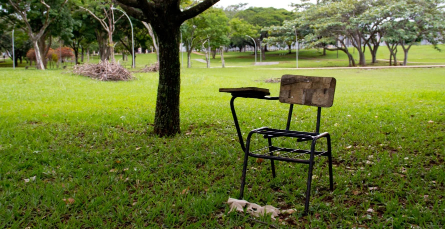 an empty chair is sitting in the grass