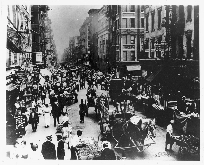 a very crowded city street filled with people and horse - drawn carriages