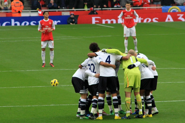 a group of people on a soccer field huddled