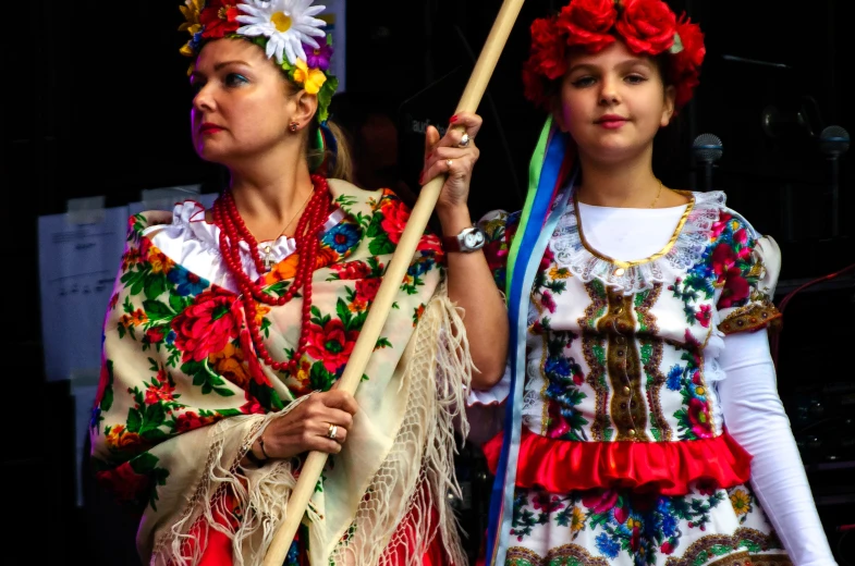 two women are standing with flags and poles