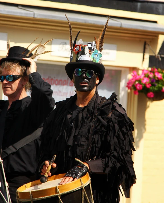 a man is standing with a drummer in front of him