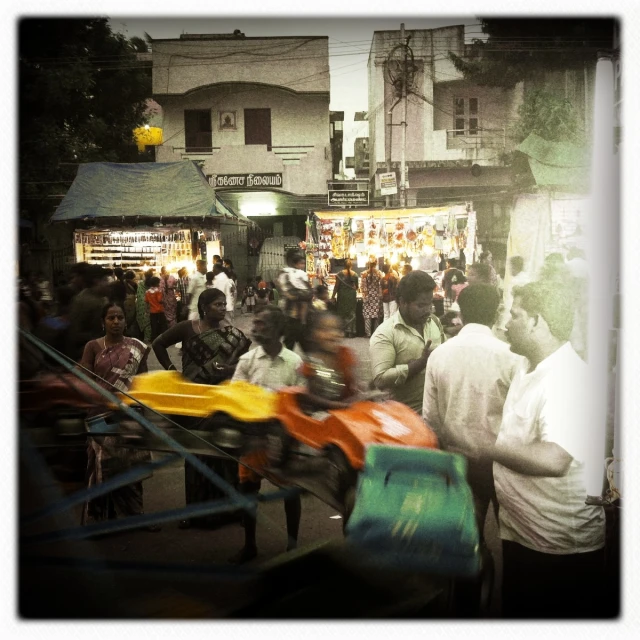 the people stand near the brightly colored items in the market