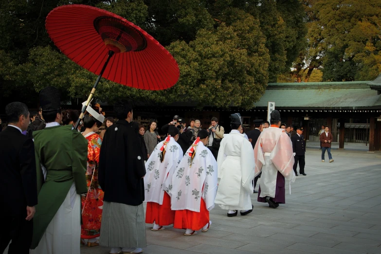 group of people dressed in kimonos and holding umbrellas