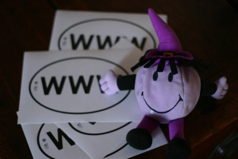 a stuffed toy with the word w, is laying on three separate white papers