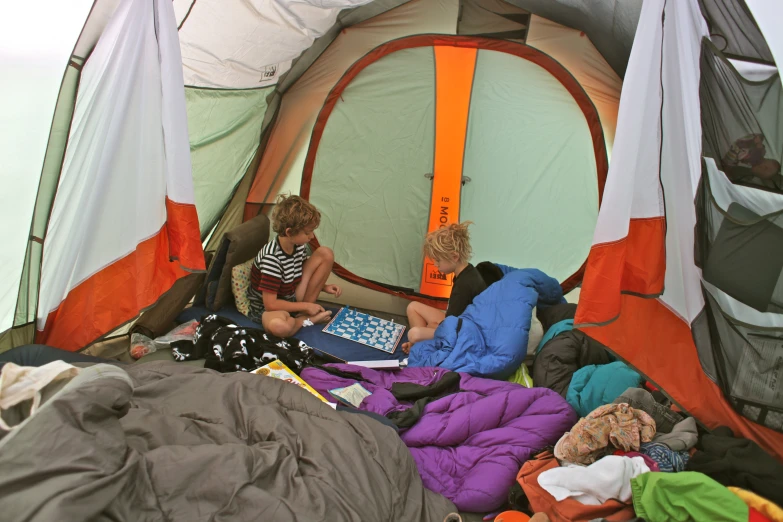 an adult and a young child set up tent outside