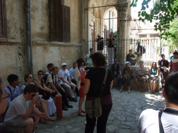 a group of people sitting on the side of a building